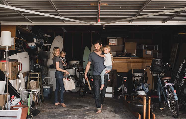 Young family tidying up a messy garage.